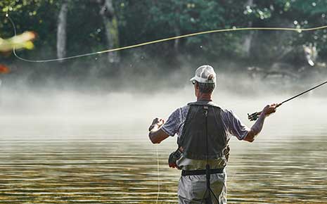A fly fisherman casting a line in a Tennessee river.
